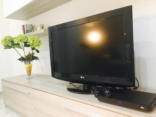 a flat screen tv sitting on top of a dresser at Queen Chic Apartment in La Spezia