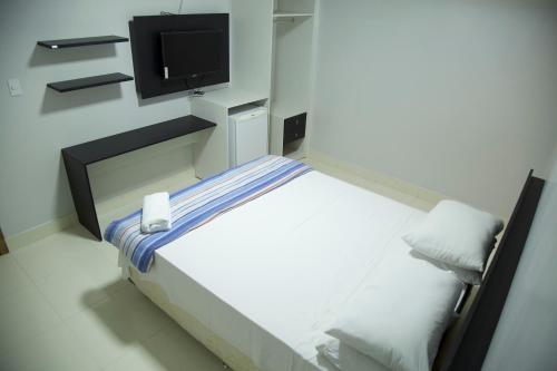a bedroom with a bed with a tv on the wall at Hotel Macapaba in Macapá