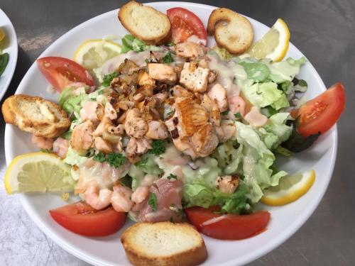 a plate of food with shrimp and lettuce and tomatoes at Villa Motel in Stenay
