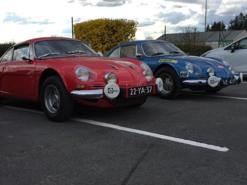 two old cars parked in a parking lot at Villa Motel in Stenay