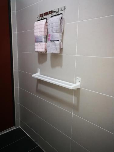 a bathroom with white towels hanging on a wall at Arianna Homestay in Pasir Gudang