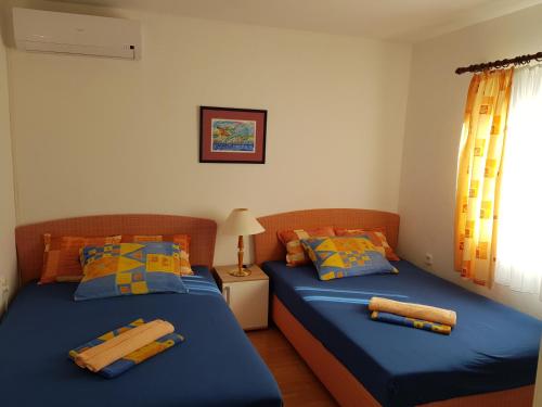 two beds sitting next to each other in a bedroom at Apartment Nera in Ledenice