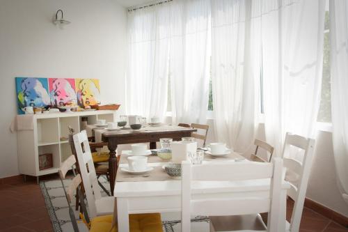 a white dining room with a white table and chairs at B&B d'amare in Villanova di Ostuni