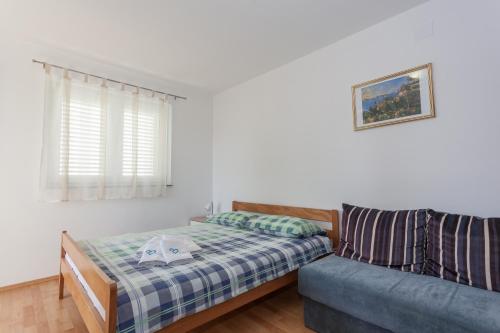 een woonkamer met een bank en een bed bij Apartments Mršić in Biograd na Moru