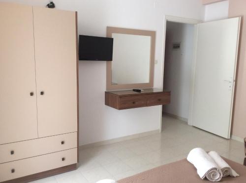 a bedroom with a mirror and a dresser and a dresser at Erato Apartments in Petalidhion