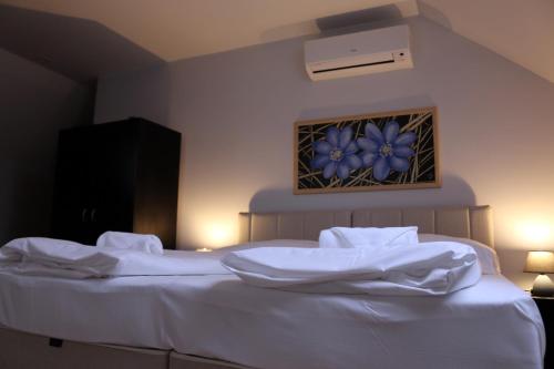 a bedroom with a white bed with blue flowers on the wall at Sörpatika Vendégház in Badacsonytomaj