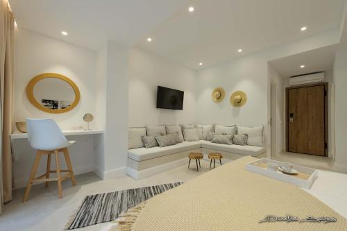 a white living room with a couch and a table at Alfa Hotel in Parga