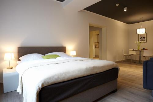 een slaapkamer met een groot bed en een tafel bij Aparthotel TU-TU in Essen