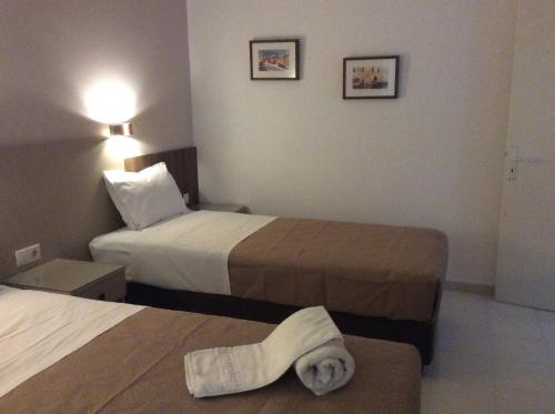 a hotel room with two beds and a towel laying on the bed at Erato Apartments in Petalidhion