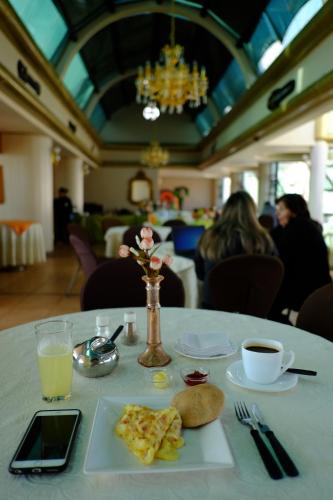 een tafel met een bord eten en een kopje koffie bij Hotel Eden By Bluebay in Oruro