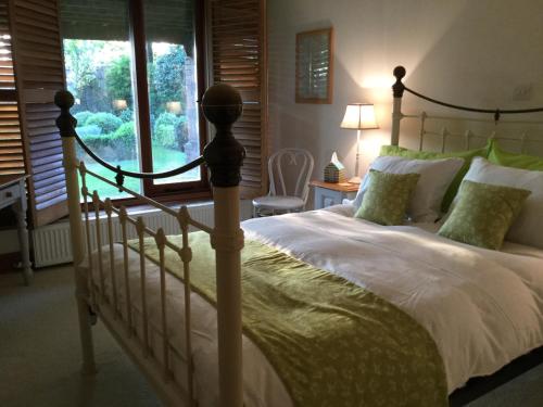 a bedroom with a large bed and a window at Heartwood Barn in Ticehurst