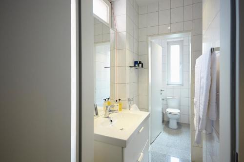 een witte badkamer met een wastafel en een toilet bij Aparthotel TU-TU in Essen