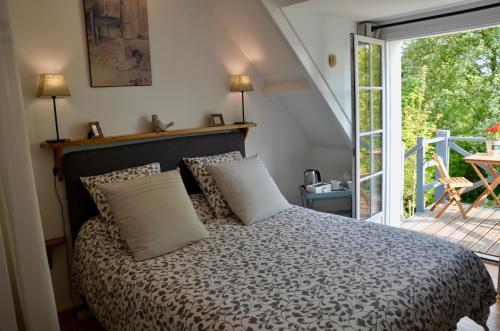 een slaapkamer met een bed en een glazen schuifdeur bij L ' Authentique in Pernes-lès-Boulogne