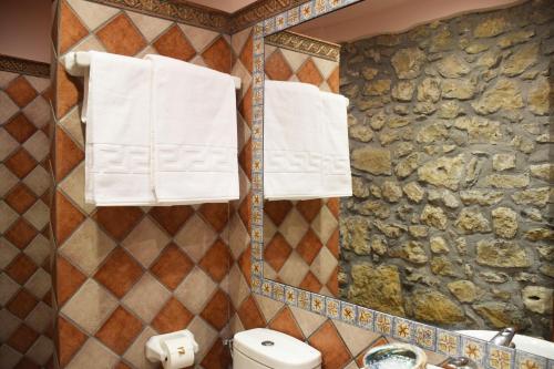 a bathroom with towels hanging on a stone wall at Hotel Hontoria in Hontoria