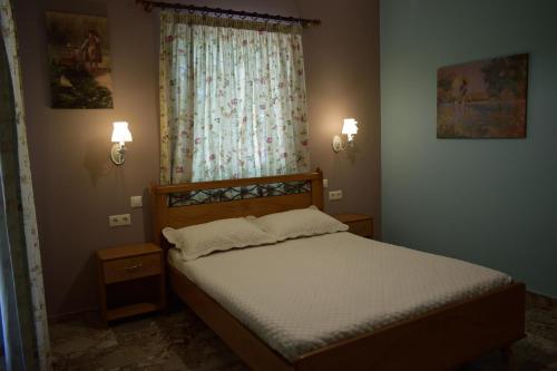a bedroom with a bed and a window and lights at Stamoulis Apartments in Agia Effimia