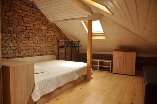 a bedroom with a bed and a brick wall at Ema Artistic House in Pleven
