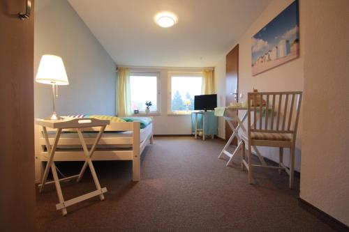 1 dormitorio con cama, mesa y escritorio en Armarova Ihre Ferienpension, en Cuxhaven