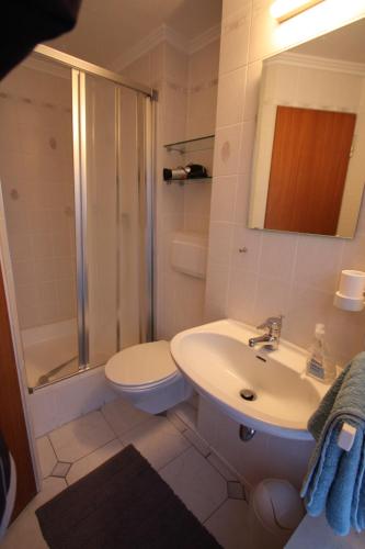 a bathroom with a toilet and a sink and a shower at Armarova Ihre Ferienpension in Cuxhaven
