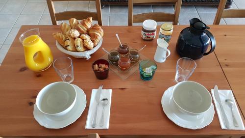 einen Tisch mit Tellern und Tassen und eine Schüssel Essen in der Unterkunft Domaine des Pêcheries in Montel-de-Gelat