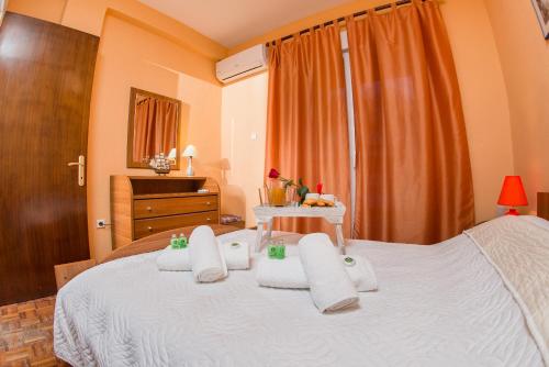 a bedroom with a bed with white towels on it at Théa Apartment in Kavala