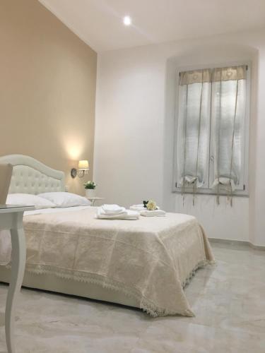 a white bedroom with a bed and a window at Queen Chic Apartment in La Spezia