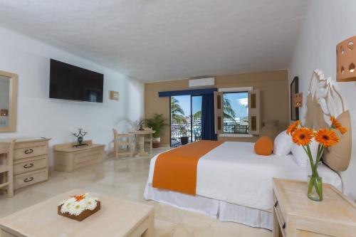 a bedroom with a bed and a room with a tv at Flamingo Vallarta Hotel & Marina in Puerto Vallarta