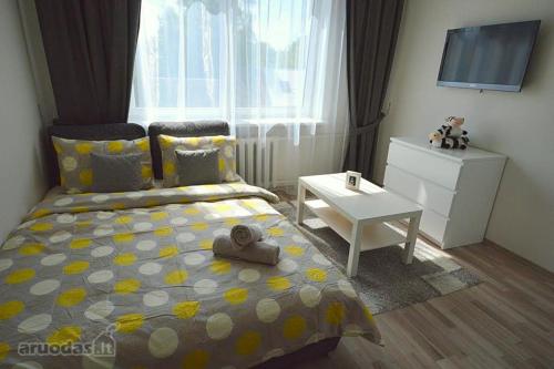 sypialnia z łóżkiem, telewizorem i stołem w obiekcie Vilnius Town Apartments w Wilnie