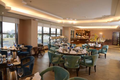 a restaurant with tables and chairs and a bar at Warwick Al Khobar in Al Khobar
