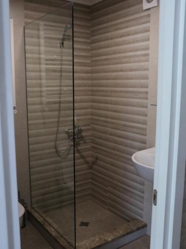 a shower with a glass door in a bathroom at Liberty Apartment And Rooms in Tbilisi City