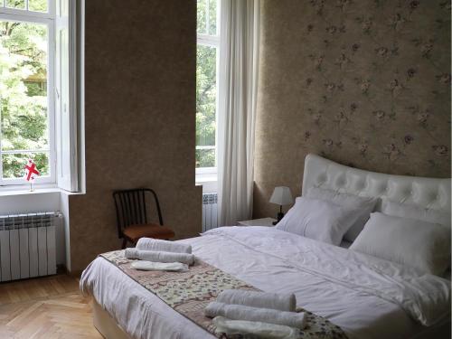 a bedroom with a large white bed with pillows on it at Liberty Apartment And Rooms in Tbilisi City