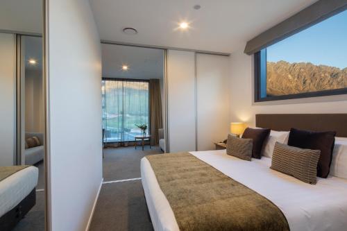 a hotel room with a bed and a large window at Wyndham Garden Remarkables Park Queenstown in Queenstown