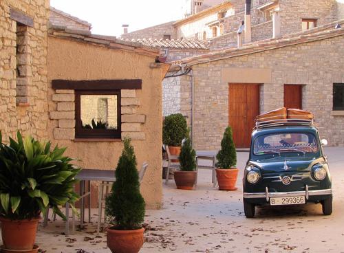 a blue car parked in front of a building at Cal Carulla in L'Astor