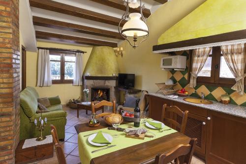a living room with a table and a fireplace at Cal Carulla in L'Astor