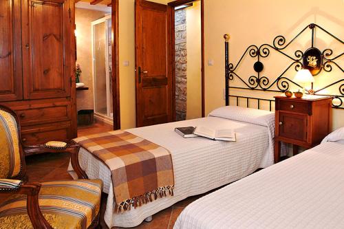 a hotel room with two beds and a chair at Cal Carulla in L'Astor