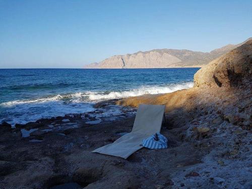 a kite sitting on a rocky beach next to the ocean at Mochlos Beach Villa Seafront house in Mochlos