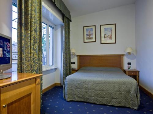 a bedroom with a bed and a tv and a window at Hotel Diplomatic in Rome