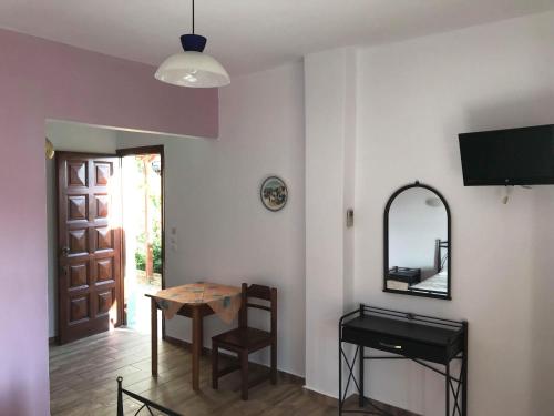 a room with a table and a mirror and a door at Elina Apartments in Batsi