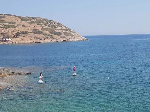 two people are standing on paddle boards in the water at Mochlos Beach Villa Seafront house in Mochlos