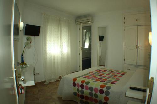 a bedroom with a bed with a polka dot blanket at El Rincón de Isabel in Conil de la Frontera