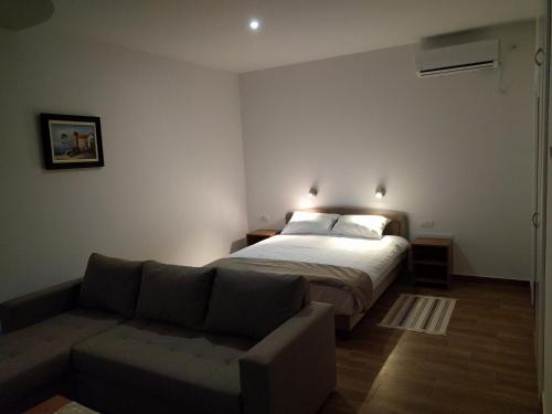 a bedroom with a bed and a couch at Simića ćoše in Vrdnik