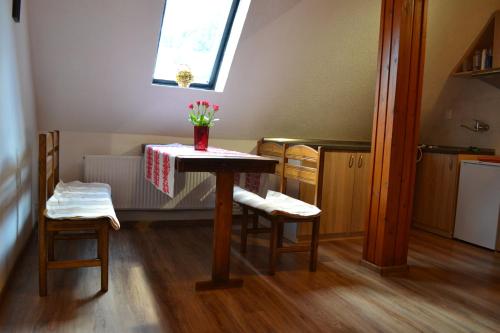 a kitchen with a table with a vase of flowers on it at Velická izba in Poprad