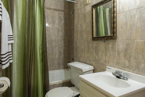 a bathroom with a sink and a toilet and a mirror at Turtle Beach Towers in Ocho Rios