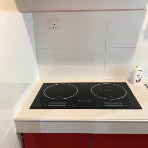 a black stove top in a white kitchen at Rumah Cik Ani in Shah Alam