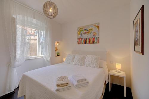 a bedroom with a white bed with towels on it at Apartment La Vida in Dubrovnik
