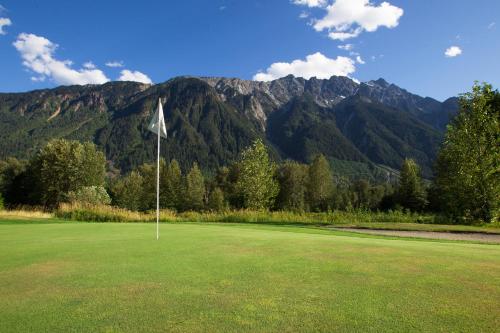 a golf course with mountains in the background and a flag at Pemberton Valley 1 bedroom suite in Pemberton