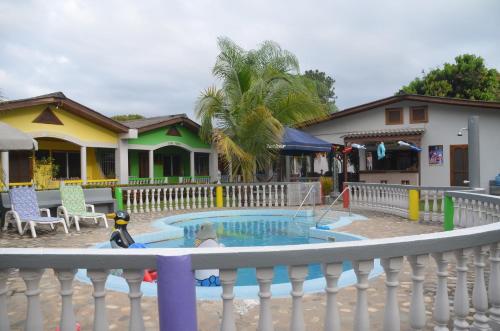 a small pool in a yard next to a house at Rainbow Village in La Ceiba