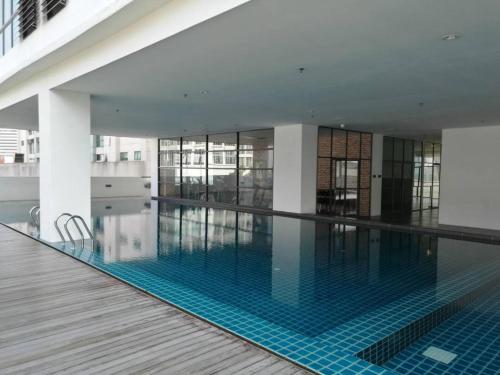 a swimming pool in a building with blue tiles at Rumah Cik Ani in Shah Alam