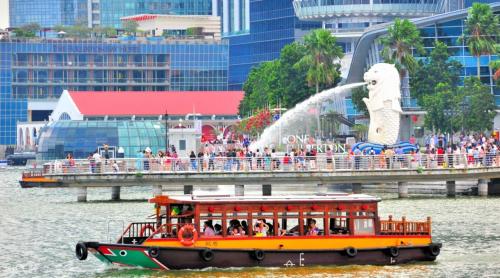 a boat in the water with people on it at BEAT. Capsule Hostel @ Boat Quay in Singapore