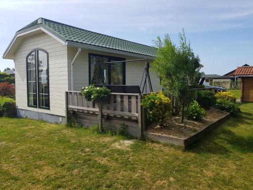 a small house with a porch and some plants at vakantiehuis in zeeland in Sint Annaland