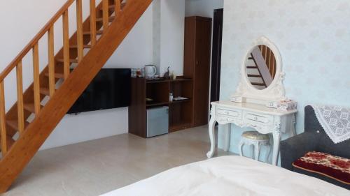 a bedroom with a bed and a table with a mirror at Gihak Homestay in Pinghe